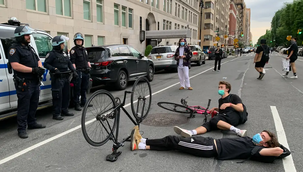 Manifestantes duermen frente a agentes de policía en el hotel internacional Trump en Columbus Circle, Central Park