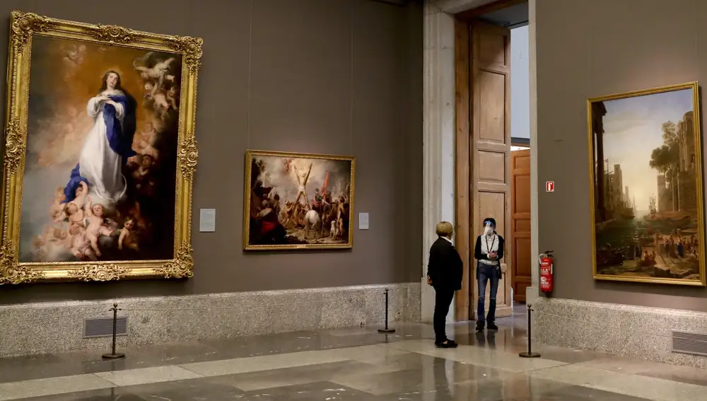 Dos empleadas del Museo del Prado con máscarillas y pantallas protectoras junto a la obra &quot;La Inmaculada Concepción de los Venerables&quot;, de Murillo