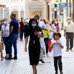 Gente con mascarillas por las calles de Sevilla