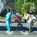 Una sanitaria acompaña a una señora mayor durante un paseo por las calles de Ponferrada