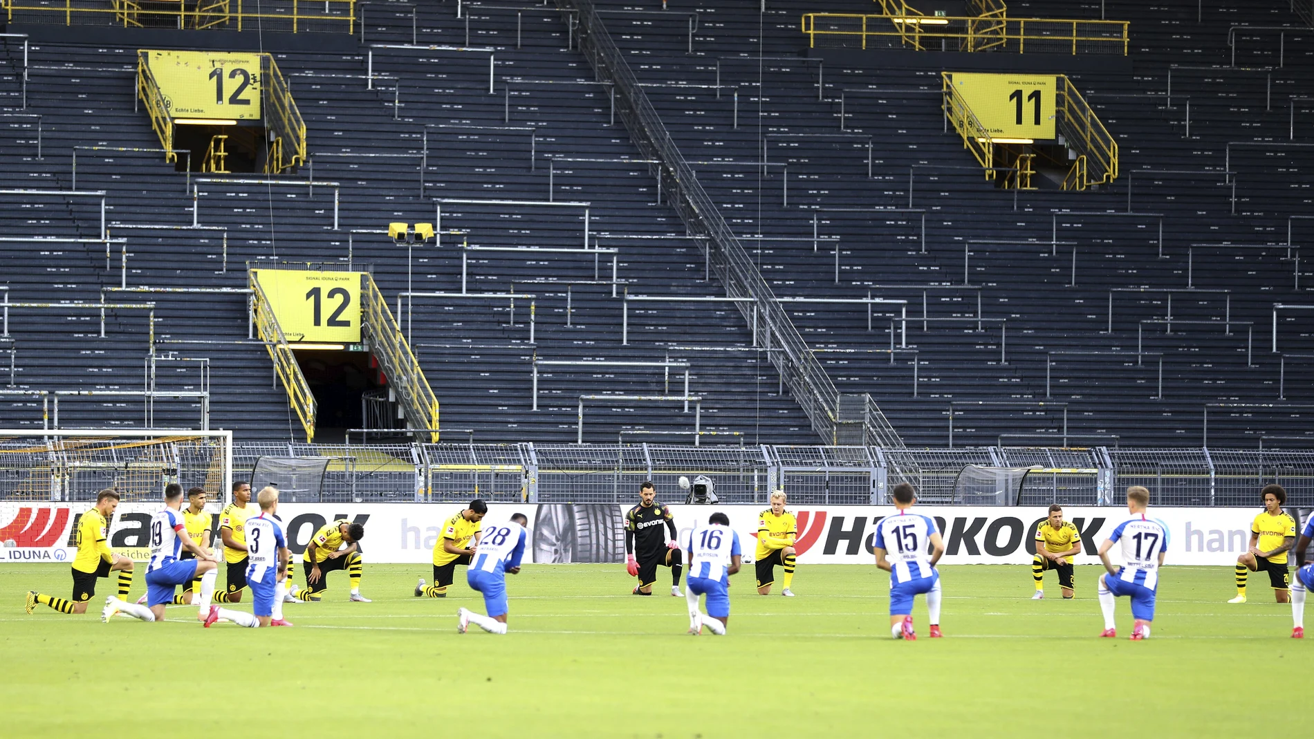 Jugadores del Dortmund y del Hertha, rodilla en tierra antes de comenzar su partido