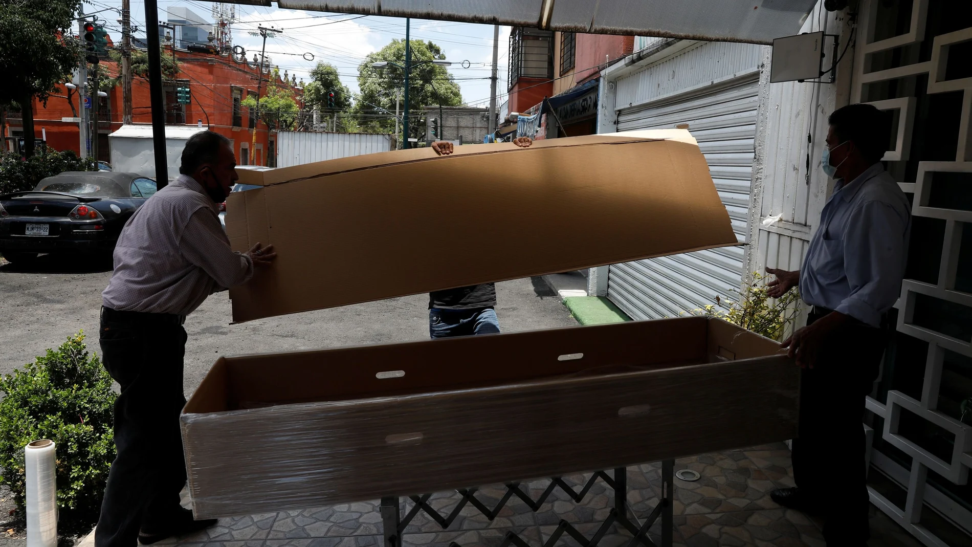 Funeral workers put together a cardboard coffin before collecting the body of a person who died of the coronavirus disease (COVID-19) in Mexico City