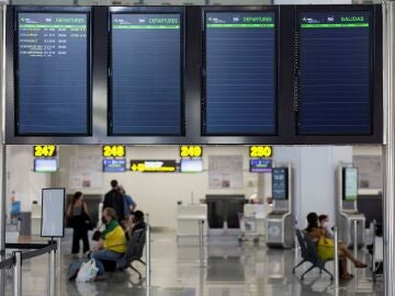 Varias personas esperan para embarcar en el aeropuerto de Málaga en uno de los escasos vuelos previsto ayer