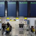 Varias personas esperan para embarcar en el aeropuerto de Málaga en uno de los escasos vuelos previsto ayer