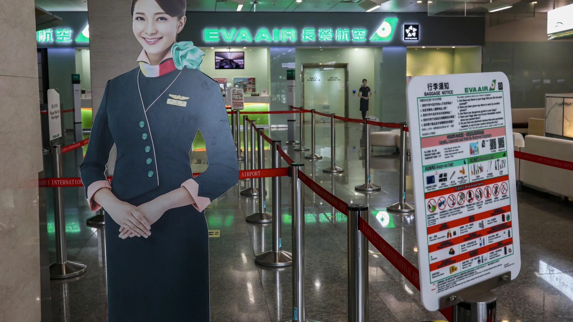 Human-sized flight attendant dummies are seen on display at an empty check-in counter for Evergreen Airways at Taipei Songshan Airport in Taipei