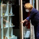 Una mujer pasea por Sevilla y visita algunos comercios durante la fase 3 de desescalada