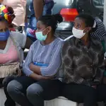 Ethiopian domestic workers wearing masks sit together with their belongings in front of the Ethiopian consulate in Hazmiyeh, Lebanon, June 8, 2020. REUTERS/Mohamed Azakir