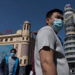 Dos personas con mascarilla en la Plaza del Callao de Madrid estrenando la "nueva normalidad"