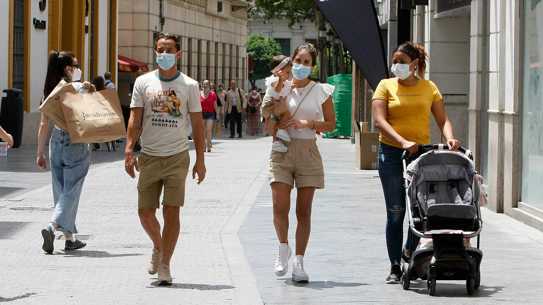 Gente con mascarillas por las calles de Sevilla