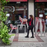 Una camarera prepara la terraza de una cervecería