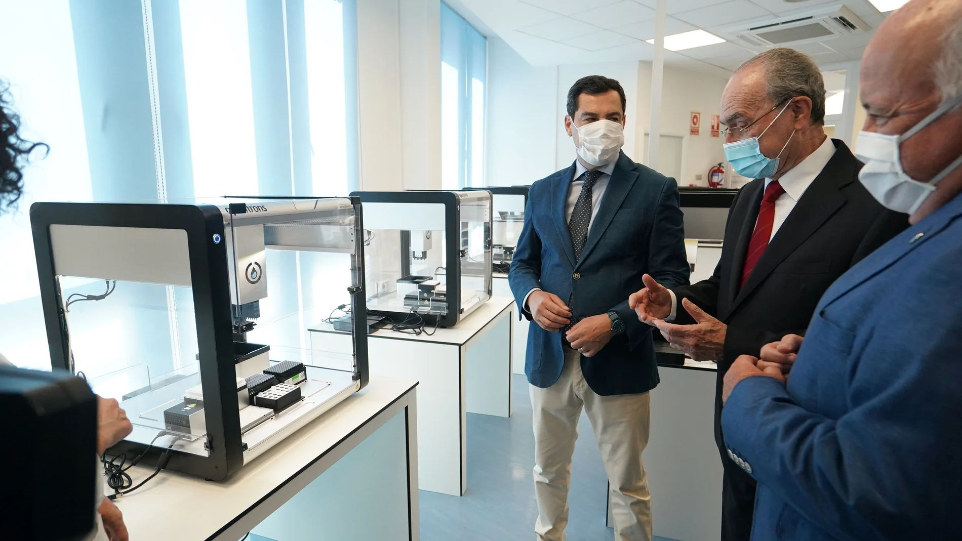 El presidente andaluz, Juanma Moreno, visita, junto con el consejero de Salud, Jesús Aguirre, y el alcalde de Málaga, Francisco de la Torre, la instalación de robots para PCR en el Hospital Regional