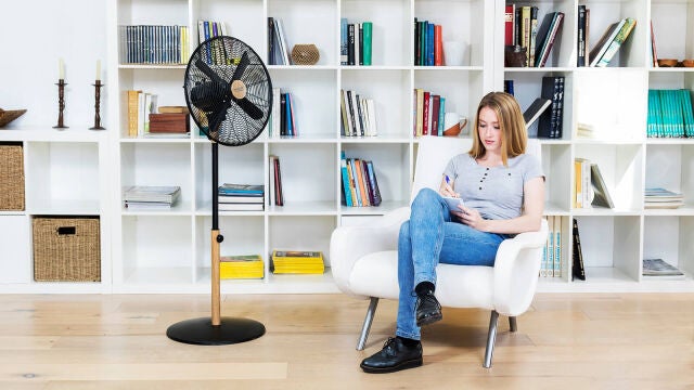 Una persona en su casa con un ventilador