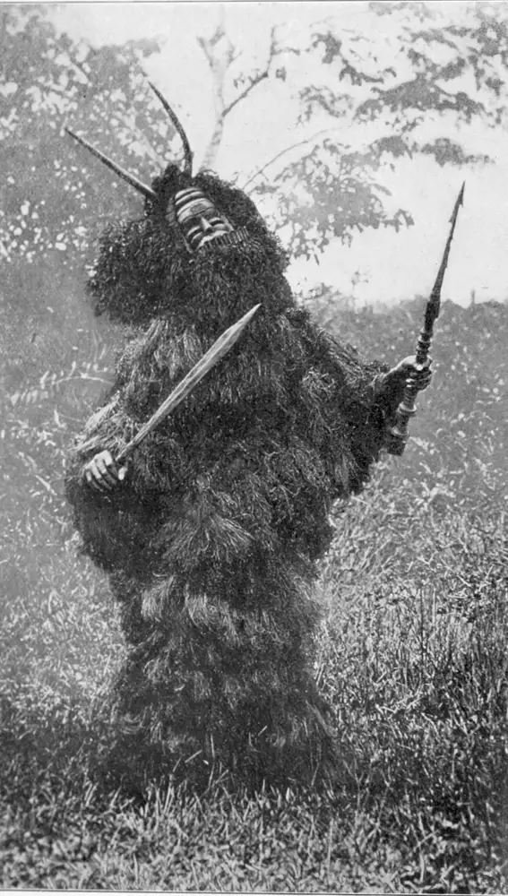 Hechicero ataviado con una máscara y hojas de palma, en una ceremonia.