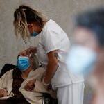Una enfermera asiste a Carmen, de 89 años, en una residencia de la Comunidad de Madrid