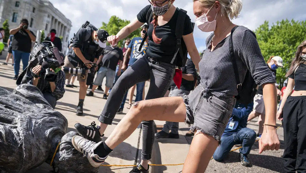 Dos manifestantes pisotean la cabeza de Critóbal Colón en Saint Paul, Minesota