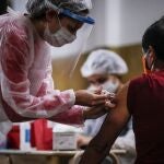 ACOMPAÑA CRÓNICA: LATINOAMÉRICA CORONAVIRUS AME6526. BOGOTÁ (COLOMBIA), 13/06/2020.- Fotografía de archivo de una enfermera vacunando a un hombre contra la gripe, el 11 de abril de 2020 al interior de una iglesia en Buenos Aires (Argentina). En medio del duro embate de la COVID-19, los países de Latinoamérica afrontan la amenaza de sufrir "dos pandemias" si no toman las medidas necesarias para asegurar la vacunación contra la influenza estacional en la región. EFE/Juan Ignacio Roncoroni