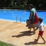 Un padre y un hijo bajan a la piscina comunitaria