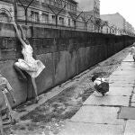 Tres niños juegan con un muro de Berlín que acaba de construirse