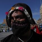 A maker of folklore costumes wearing a face mask amid the new coronavirus pandemic attends a protest against the government's recent closing of the Culture Ministry, and to demand it reopen in La Paz, Bolivia, Monday, June 15, 2020. The government has closed the ministries of culture, sports, and communication, citing the need to cut costs. (AP Photo/Juan Karita)