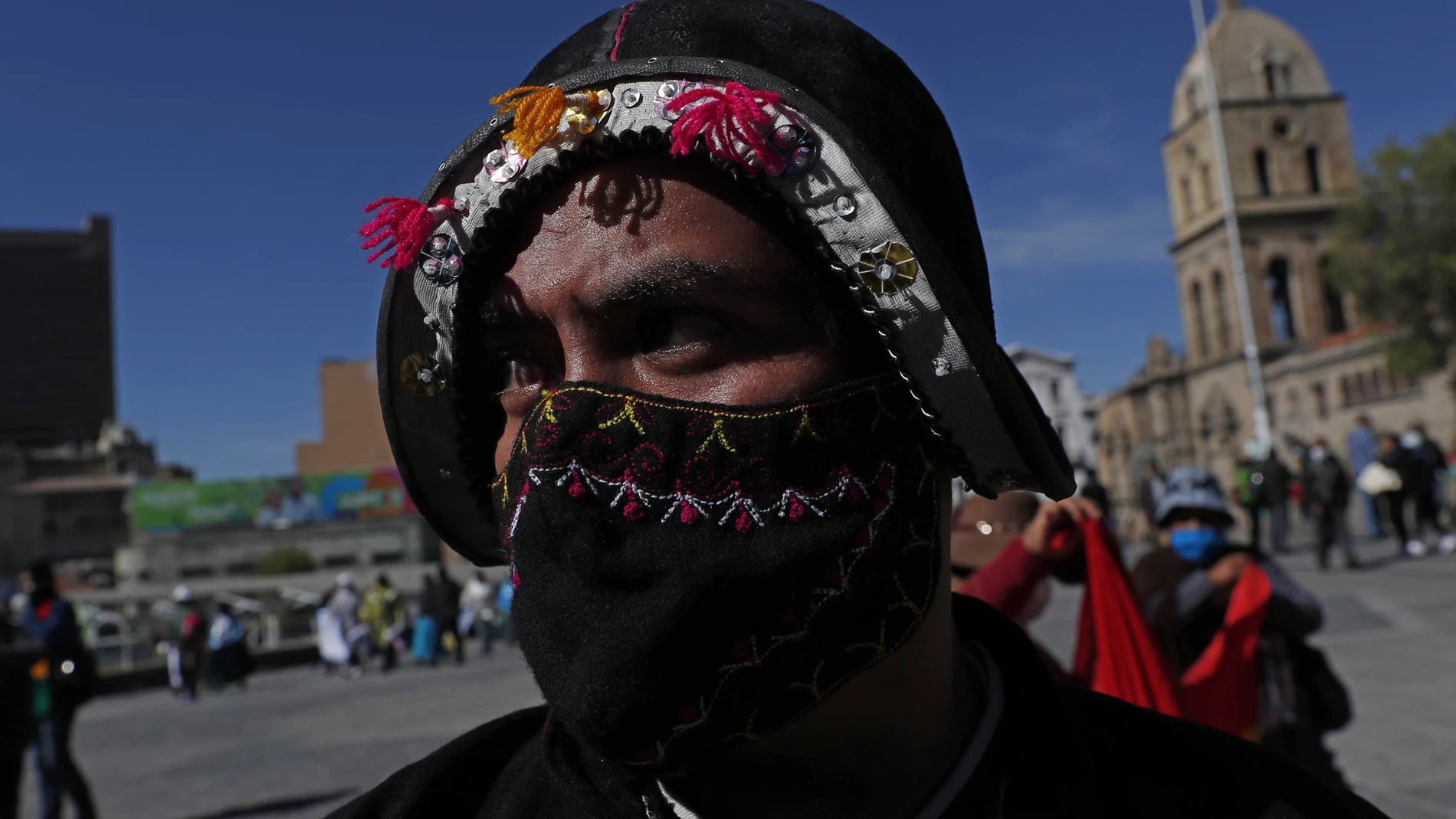 A maker of folklore costumes wearing a face mask amid the new coronavirus pandemic attends a protest against the government's recent closing of the Culture Ministry, and to demand it reopen in La Paz, Bolivia, Monday, June 15, 2020. The government has closed the ministries of culture, sports, and communication, citing the need to cut costs. (AP Photo/Juan Karita)