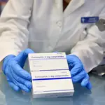 Un profesional farmacéutico de Madrid muestra unas cajas de  Fortecortin, un medicamento que contiene  dexametasona, desaconsejado para pacientes leves y, desde luego, para personas sanas