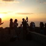 Varios jóvenes disfrutan de una puesta de sol en Palma de Mallorca