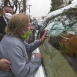 A friend of 72-year-old Monica Lagos, touches the hearse with the coffin containing her body, outside her home in Santiago, Chile, Monday, June 15, 2020. According to grandaughter Ninoska Vasquez, who works as an assistant at a health center, Lagos died from complications related to COVID-19. (AP Photo/Esteban Felix)