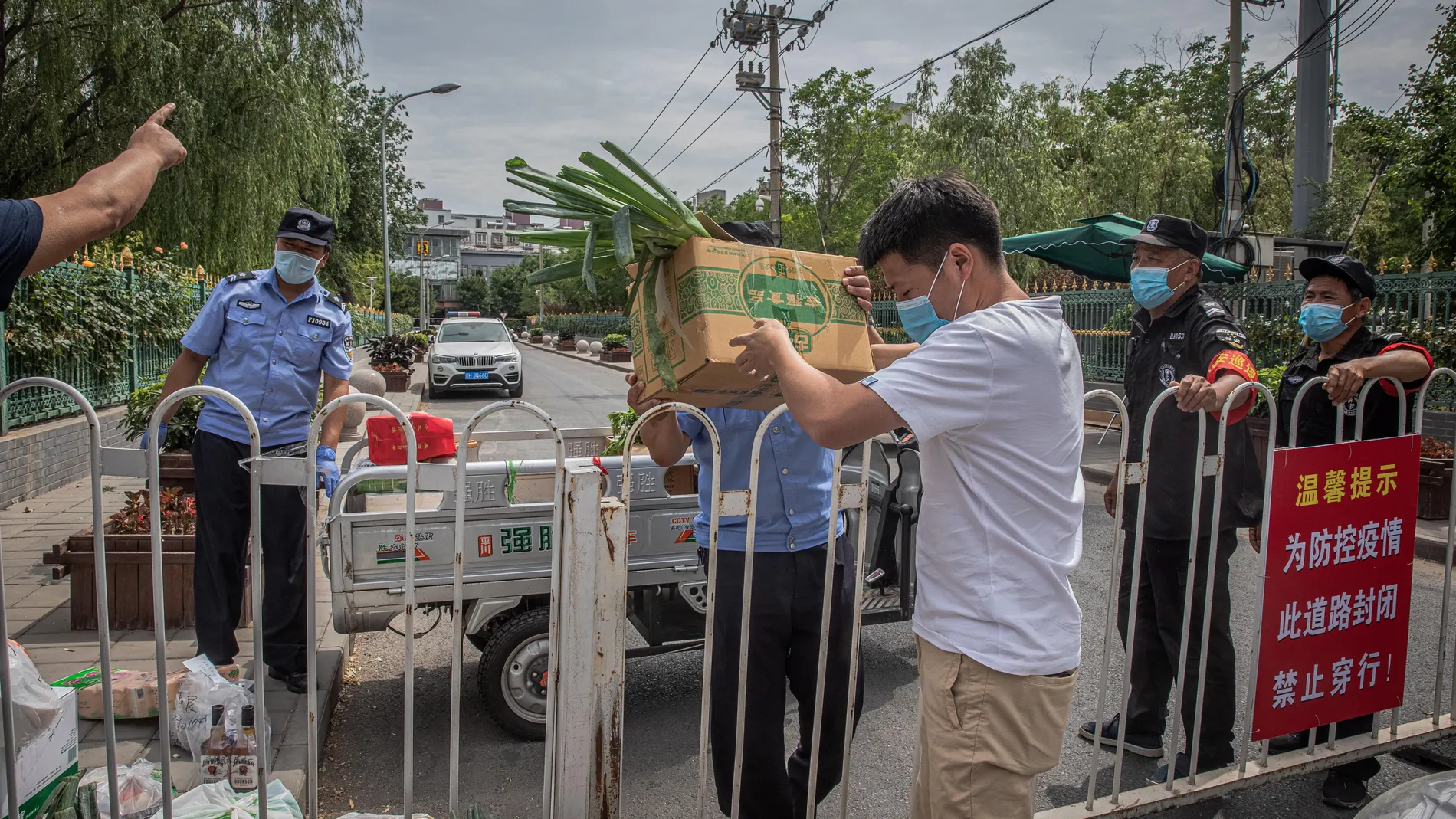 Un hombre trae cajas de comida a una de las áreas residenciales clausurads en el distrito de Fengtai en la capital