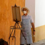 Un pintor callejero de Sevilla realiza sus labores cumpliendo con la normativa de seguridad vigente durante la fase 3 de desescalada
