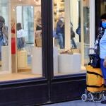 Una mujer observa un escaparate en Sevilla durante la fase tres de desescalada