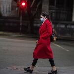 A woman wearing a protective face mask as a measure to curb the spread of the new coronavirus, walks in downtown Montevideo, Uruguay, Monday, June 15, 2020. Life is slowly returning to normal in Uruguay, while Latin America is still in the middle of the storm fighting COVID-19. In Montevideo, where there are only three confirmed cases, businesses reopened its doors weeks ago. (AP Photo/Matilde Campodonico)