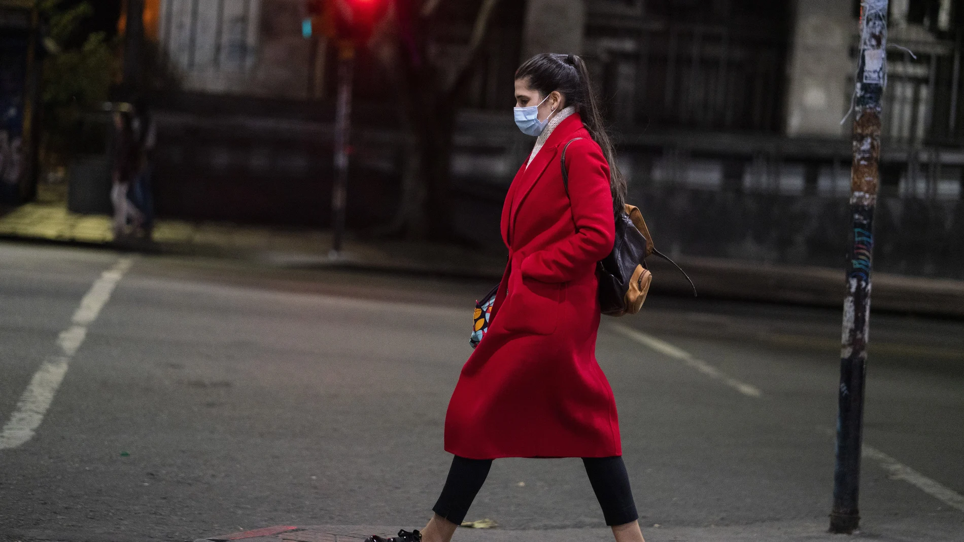 A woman wearing a protective face mask as a measure to curb the spread of the new coronavirus, walks in downtown Montevideo, Uruguay, Monday, June 15, 2020. Life is slowly returning to normal in Uruguay, while Latin America is still in the middle of the storm fighting COVID-19. In Montevideo, where there are only three confirmed cases, businesses reopened its doors weeks ago. (AP Photo/Matilde Campodonico)