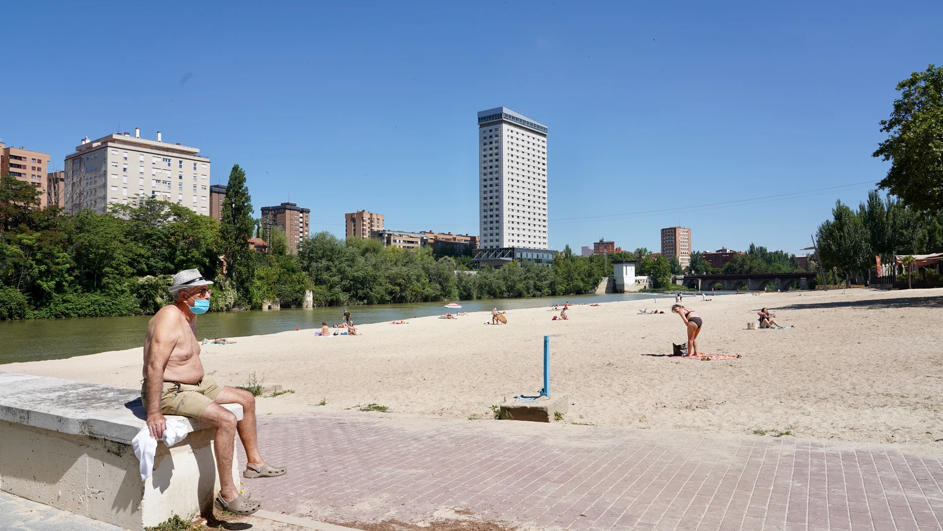 Varias personas toman el sol en la Playa de las Moreras de Valladolid