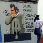 Una mujer se hace un selfie con un grafiti de Fernando Simón en en el barrio de Benimaclet de Valencia