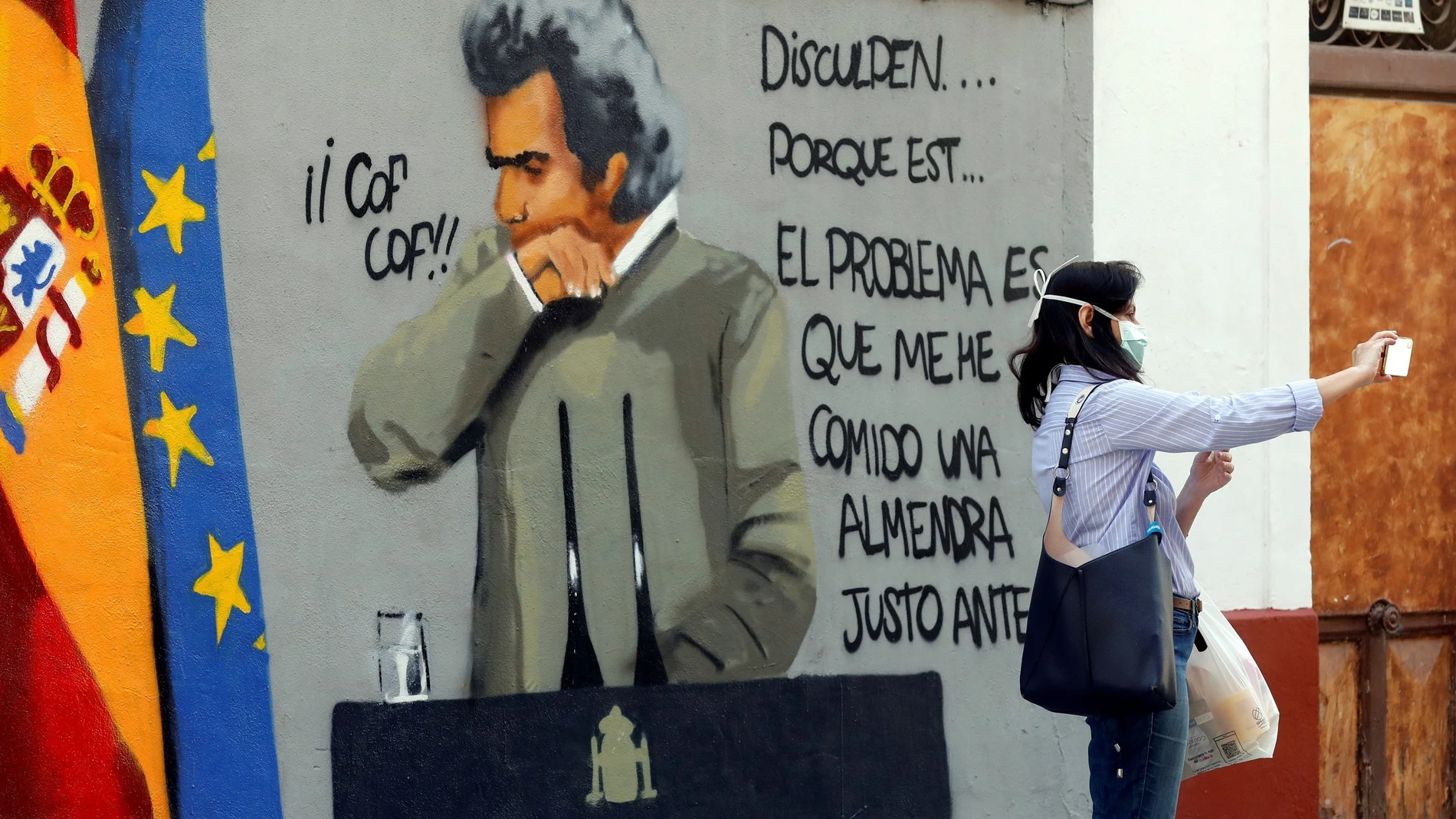 Una mujer se hace un selfie con un grafiti de Fernando Simón en en el barrio de Benimaclet de Valencia