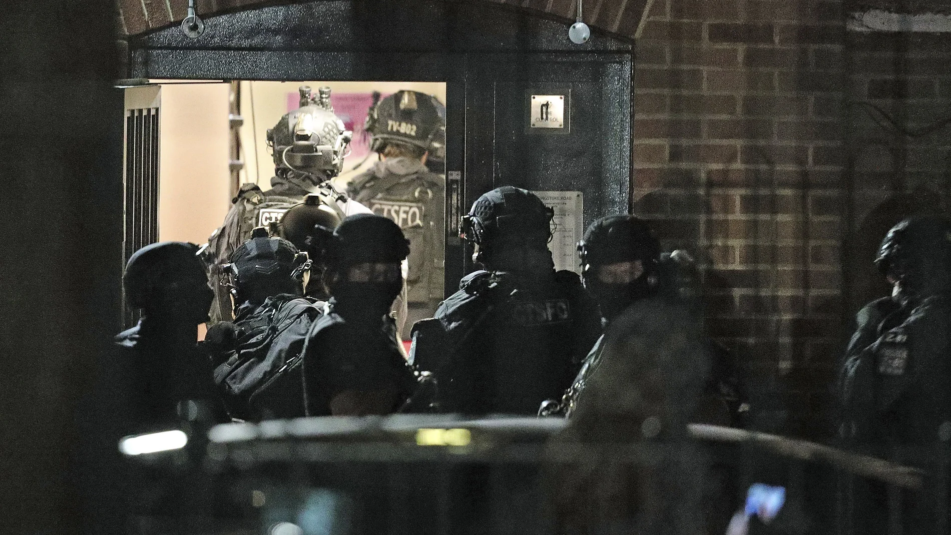 Oficiales de policía armados investigan en un bloque de apartamentos de Basingstoke Road en Reading