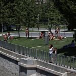 Varias personas toman el sol en los jardines de Madrid Rio este lunes durante el segundo día oficial del verano