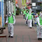 Un grupo de trabajadores desinfectan una calle de Corea del Sur