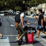 Varias personas con maletas caminan por el centro de Málaga tras el fin del estado de alarma