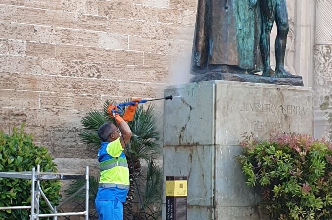 Un operario limpia la pintada de la estatua de Juníper Serra