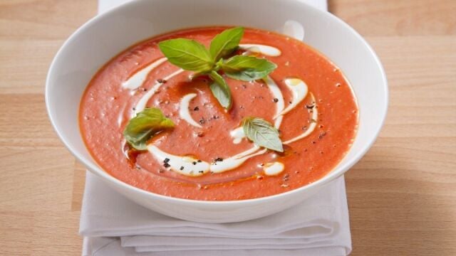 Plato de gazpacho con crema y albahaca