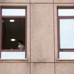 Una persona habla por teléfono en una ventana del Centro de Acogida, Emergencia y Derivación de Cruz Roja en Málaga donde el martes detectó un foco de contagios de coronavirus