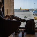 Un viajero espera su vuelo mientras observa una de las pistas del aeropuerto de San Pablo en Sevilla