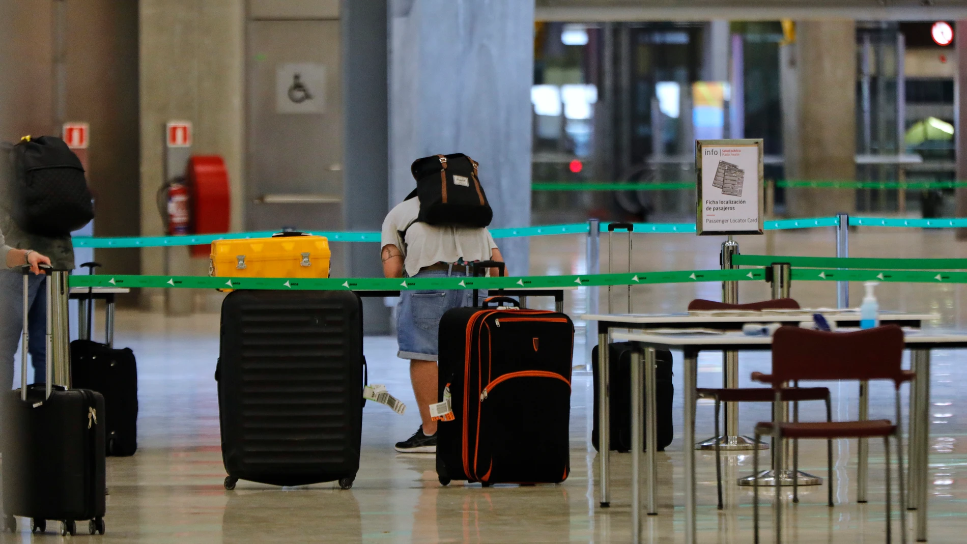 Un pasajero procedente de Londres rellenan un formulario a su llegada al Aeropuerto de Madrid-Barajas Adolfo Suárez