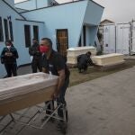 Trabajadores funerarios mueven en ataúd en Perú