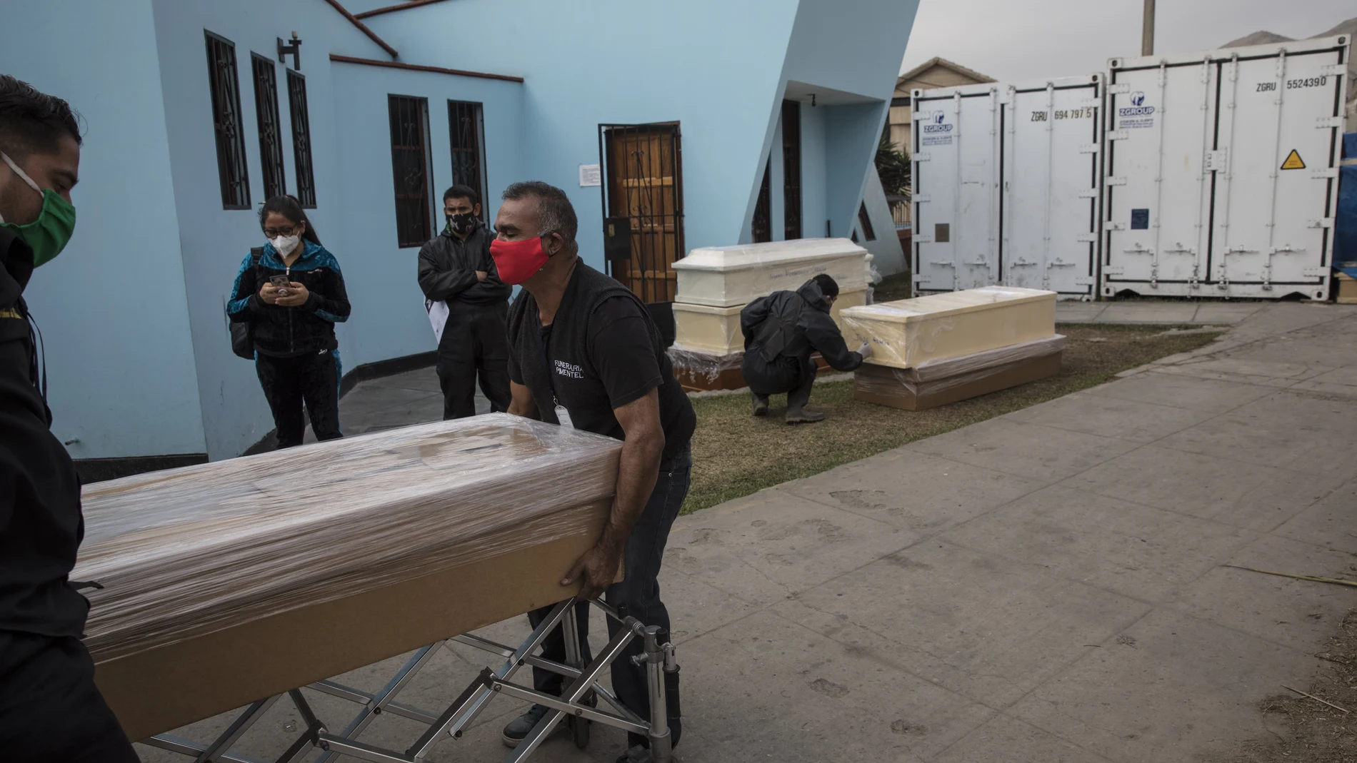Trabajadores funerarios mueven en ataúd en Perú