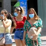 Tres mujeres transitan por una calle equipadas con mascarillas para frenar los contagios de la Covid-19