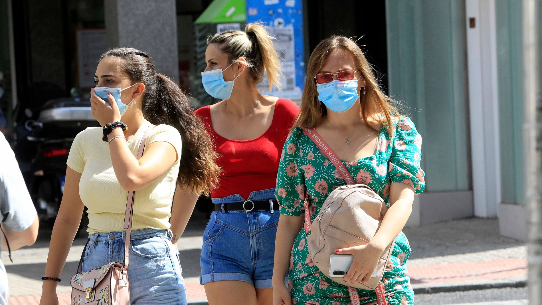Tres mujeres transitan por una calle equipadas con mascarillas para frenar los contagios de la Covid-19