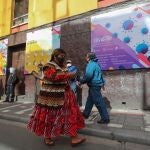 AME8811. LA PAZ (BOLIVIA), 25/06/2020.- Personas pasan frente a un carteles con información sobre COVID-19 este jueves, a tres meses de la cuarentena decretada por la pandemia de COVID-19, en La Paz (Bolivia). EFE/Martin Alipaz