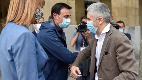 El ministro del Interior, Fernando Grande-Marlaska (d), saluda antes de intervenir este viernes en un mitin electoral en Portugalete (Bizkaia) junto a la secretaria general del PSE-EE y candidata a lehendakari, Idoia Mendia (i), y el alcalde de la localidad, Mikel Torres (c).